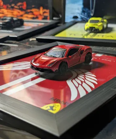 Close-up of a red Ferrari F8 3D Diecast Metal Car Frame by ARTZAY, showcasing the 1:43 scale model and premium 10.5x8.5 inch black frame, ideal for stylish wall decor in a boys' room or car enthusiast's space, available on Khareedo Pakistan with check on delivery service.