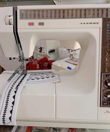 ** Janome Memory Craft 6500 (P) computerized sewing and quilting machine with a beige/cream body, brown control panel, large throat space, and detailed decorative stitching on fabric.