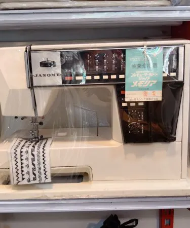 Janome Sewing Machine 5002 (110 volt) with voltage regulator, showcasing its heavy-duty mechanical build, 33 stitch options, and LED light on a sewing table, available at Khareedo Pakistan.