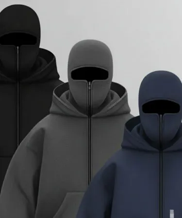 A male model wearing a navy blue balaclava hoodie made from soft winter fleece, showcasing the face covering feature and comfortable fit.