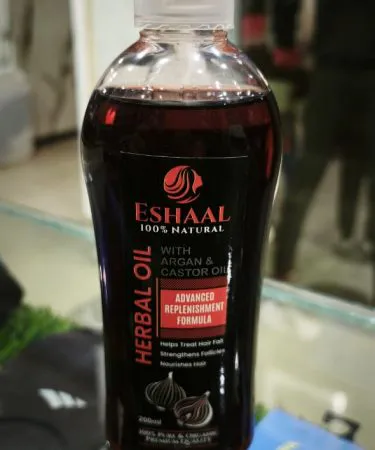 Eshaal Herbal Hair Oil bottle with natural ingredients and healthy hair illustration**