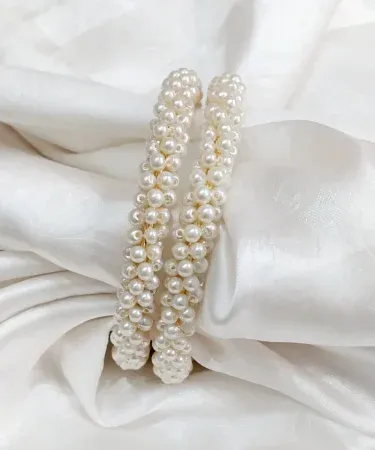 Two elegant free size pearl bangles, a two-piece set featuring lustrous pearls, displayed on a minimalist background. Perfect for Pakistani traditional wear or modern outfits. Buy online with Khareedo and Kharedo with check on delivery.