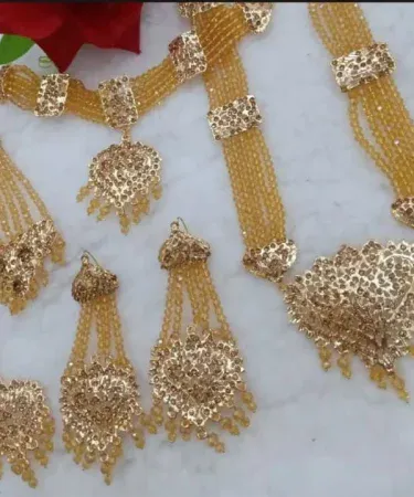 New style gold plated bridal set for women, fashionable design with necklace, earrings, tikka, and bangles, perfect for Pakistani weddings.