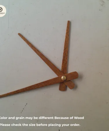 Close-up view of elegant wooden clock hands and needles, showcasing their natural wood grain and craftsmanship.