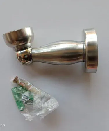 Sleek, modern stainless steel door stopper protecting a wooden door from hitting a wall, showcasing its best quality and universal design.