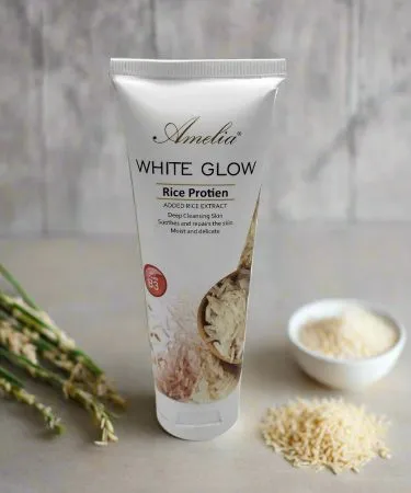 Amelia White Glow Rice Face Wash bottle with rice grains background, imagecaption=Amelia White Glow Rice Face Wash – Brightening Cleanser for Radiant Skin,