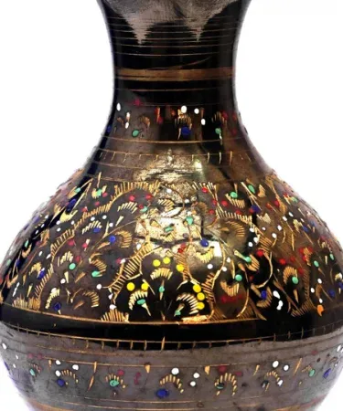 Handcrafted decorated brass flower vase with antique black and gold finish, wavy rim, and multicolor engraved patterns displayed on a wooden table, imagecaption=Elegant brass flower vase – perfect for home and office décor.