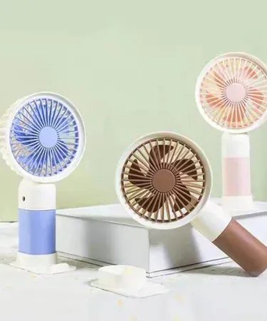 Cute Mini Rechargeable Fan with Mobile Phone Holder – portable pocket‑size cooling fan for indoor and outdoor use, featuring built‑in phone holder and USB charging.