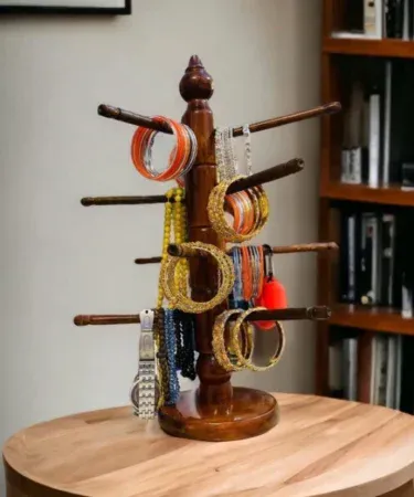 Elegant round jewellery stand with multiple hooks and trays for necklaces, bracelets and rings, displayed on a wooden tabletop.