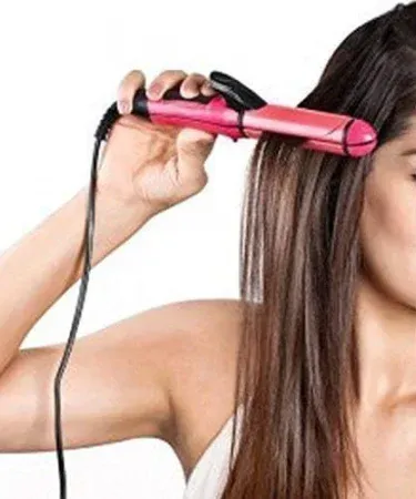 Abū Turāb (أبو تراب) 2‑in‑1 Straightener & Curler with rotating cord and ceramic plates, sleek black design, shown on a marble countertop.