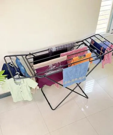 Cloth dryer stand made of rust‑proof metal, holding freshly washed clothes on a balcony – Khareedo product