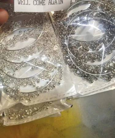 Elegant set of traditional Kashmiri glass and enamel bangles displayed on a marble surface, showcasing vibrant colors and intricate designs.