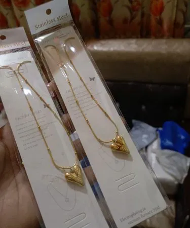 Premium stainless steel kitchenware set with pots, pans, and cutlery displayed on a modern kitchen countertop