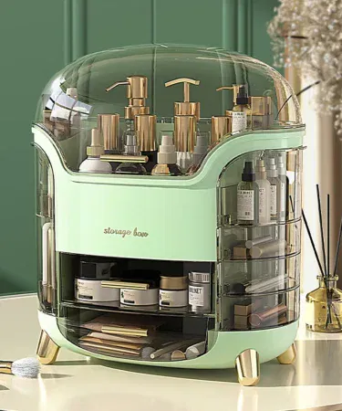 Clear multi‑compartment makeup organizer displaying lipstick, brushes, jewelry and skincare items on a vanity table, imagecaption=Elegant clear makeup organizer for tidy vanity – available on Khareedo | Kharedo.