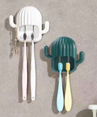 Cactus‑shaped wall‑mounted toothbrush and razor holder with open‑bottom drainage design, imagecaption=Stylish cactus toothbrush holder – punch‑free adhesive wall mount for organized, dry bathroom essentials.