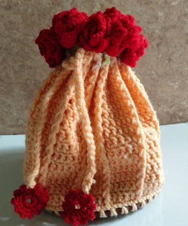 Handmade peach crochet bouquet potli bag with red floral accents