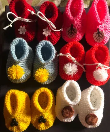 Handmade crochet baby booties soft newborn shoes, cozy knitted footwear for infants, imagecaption=Adorable handmade crochet baby booties – perfect soft shoes for newborns.