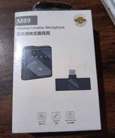 Wireless Lavalier microphone M89 – compact clip‑on mic for vloggers and presenters , imagecaption=Wireless Lavalier microphone M89 displayed on a studio desk, highlighting its sleek design and portable size ,