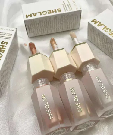 SheGlam Glow Liquid Highlighter in elegant bottle with shimmering light reflection, showcasing Pearl Glow, Rose Gold, and Bronze Gleam shades.