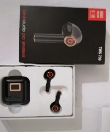 TWS 730 true wireless stereo earbuds in sleek black finish, showing earbuds and charging case on a modern desk