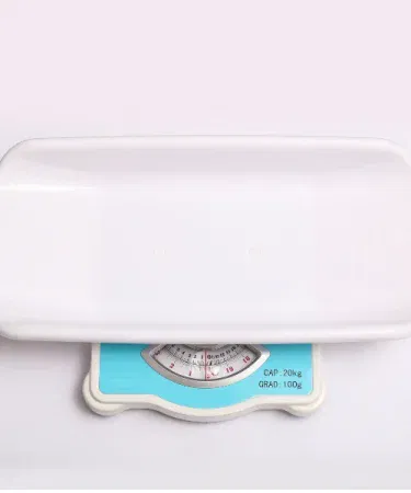 Analog baby weight scale showing clear dial and newborn on platform, imagecaption=High‑quality analog baby weight scale – accurate, portable, and safe for newborns and infants.