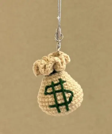 Handmade crochet dollar sign money bag keychain with durable keyring, perfect for keys and bags in Pakistan.