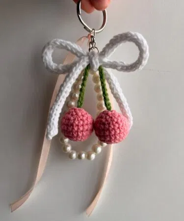 Handmade crochet double ball keychain with ribbon and bead tassel charm, sold in Pakistan.
