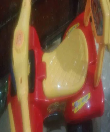 Red and yellow kids mini scooter with lights and sounds, made of plastic, for ages 2-6, sold in Pakistan.