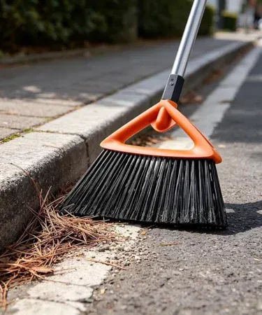 Commercial-grade grey outdoor broom with stiff bristles for heavy-duty sweeping on patios and garages.