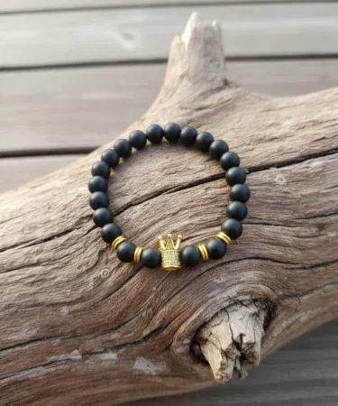Lion head and crown men's women's bracelet with black beads and gold crown centerpiece.