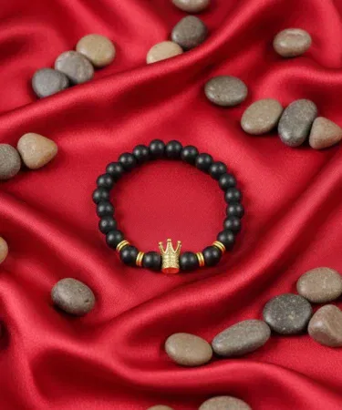 Lion head and crown men's women's bracelet with black beads and gold crown centerpiece.